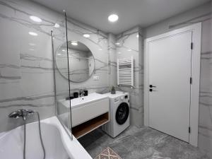 uma casa de banho com um lavatório e uma máquina de lavar roupa em Renthouse Apartments Level Up em Chisinau