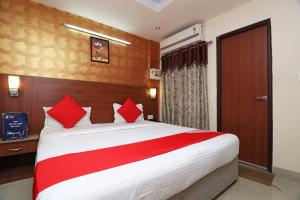 a bedroom with a large bed with red pillows at OYO Mj International in Lucknow