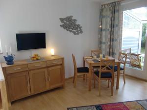 Una sala de estar con una mesa y un televisor. en Ferien Haus Pelle, en Pelzerhaken