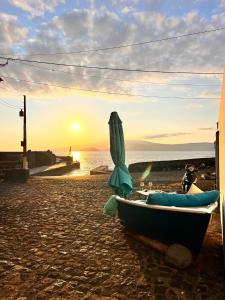 una barca con ombrellone sulla spiaggia al tramonto di Convés a Monte
