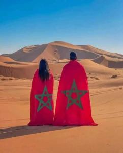 a man and woman sitting in the desert at Dar Fes Marrakech in El Hajeb