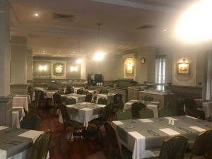 une salle à manger avec des tables et des chaises blanches dans l'établissement Windsor Hotel, à Sliema