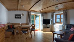 ein Wohnzimmer mit einem Tisch und einem Sofa in der Unterkunft Ferienwohnung Mathias Kennerknecht in Fischen im Allgäu