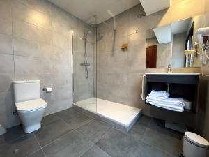 uma casa de banho com um chuveiro, um WC e um lavatório. em Tudel em Andorra-a-Velha