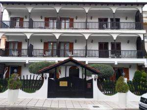 a large white building with a black door at Amaryllis House in Platamonas