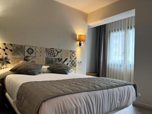 a bedroom with a large bed and a window at Tudel in Andorra la Vella