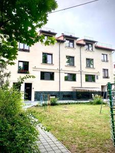 a large white building with a yard in front of it at Plai Hotel in Chişinău