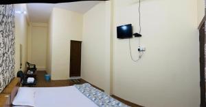 a bedroom with a bed and a tv on a wall at RN Residency in Varanasi