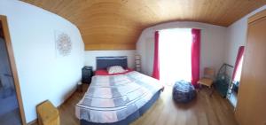 a bedroom with a bed in a room with a wooden ceiling at 1 Zimmer in Kestenholz in Kestenholz