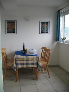 tavolo e sedie con una bottiglia di vino sopra di Haus Klara a Detzem