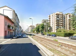 a city street with parked cars and buildings at Xenia Apartments - New and Bright Urban Housing in Milan