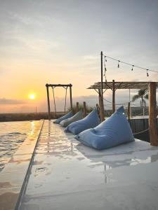 - une rangée d'oreillers bleus sur une jetée au coucher du soleil dans l'établissement the AMARTYA, à Yogyakarta