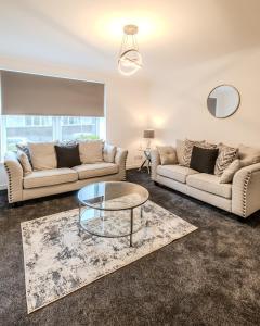 a living room with two couches and a table at Central City Hideaway - Luxury 2 Bed city centre Apartment in Aberdeen
