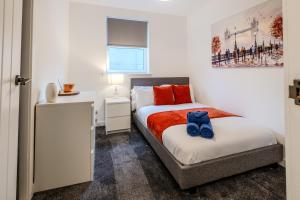 a bedroom with a bed and a table and a picture at Central City Hideaway - Luxury 2 Bed city centre Apartment in Aberdeen