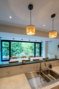 une cuisine avec un évier et une grande fenêtre dans l'établissement Li Rotche, à La-Roche-en-Ardenne