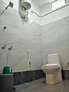 een badkamer met een toilet en een douche bij Reves by Le Apex in Kottakupam