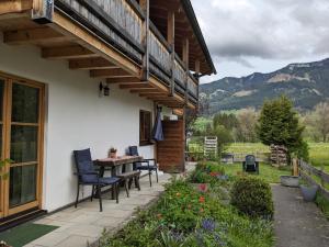 a patio with chairs and a table on a house at Ferienwohnung Mathias Kennerknecht in Fischen