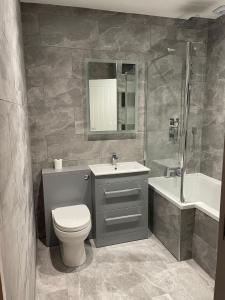 La salle de bains est pourvue de toilettes, d'un lavabo et d'une baignoire. dans l'établissement Bond Street Mayfair Penthouse, à Londres