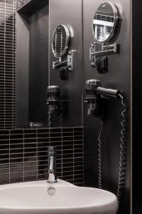 a bathroom with a sink with a blow dryer and a mirror at Perla Hotel in Prague