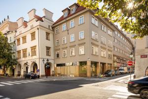 a large building on a city street with cars parked at Perla Hotel in Prague