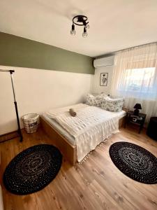 ein Schlafzimmer mit einem Bett und zwei Teppichen auf dem Boden in der Unterkunft Füge Vendégház in Magyarhertelend