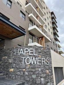 a sign on a wall in front of a building at Modern Apartment in Chapel Towers in Cape Town