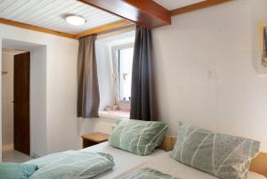 1 dormitorio con 1 cama con 2 almohadas y ventana en Wasserfall, en Stall