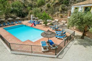 an outdoor swimming pool with chairs and umbrellas at Padre Aviles in Olías