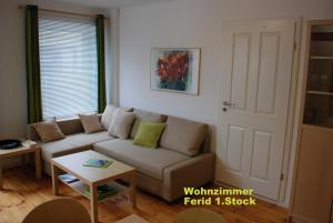 新城荷斯坦的住宿－Haus am Hafen，客厅配有沙发和桌子