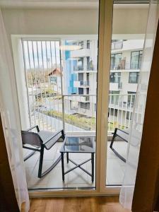 einen Balkon mit 2 Stühlen und einem Glastisch in der Unterkunft Joy City Stay Mara M10-12 in Timişoara