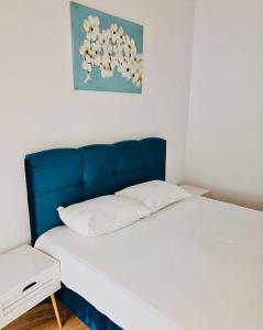 Bett mit blauem Kopfteil in einem Zimmer in der Unterkunft Joy City Stay Mara M10-12 in Timişoara