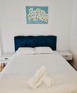 ein weißes Bett mit zwei weißen Handtüchern darauf in der Unterkunft Joy City Stay Mara M10-12 in Timişoara