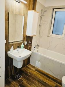 ein Badezimmer mit einem Waschbecken, einem WC und einer Badewanne in der Unterkunft Joy City Stay Mara M10-12 in Timişoara