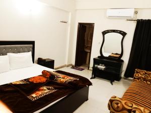 1 dormitorio con 1 cama y vestidor con espejo en Hotel Khursheed Palace, en Rawalpindi