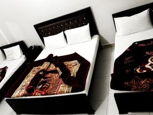 two beds sitting next to each other in a room at Hotel Khursheed Palace in Rawalpindi