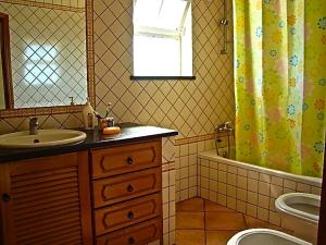 a bathroom with a sink and a shower curtain at Bella & Gordinho GuestHouse in Lagos