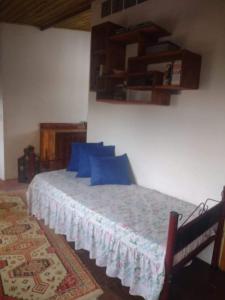 1 dormitorio con 1 cama con almohadas azules en Recanto da minha flor - Praia da Pinheira en Palhoça