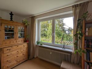 ventana en una habitación con radiador y cómoda en Ferienwohnung Am Seebach, 80 Qm en Titisee-Neustadt