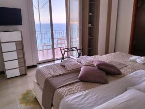 two beds in a room with a view of the ocean at Villa Paradise (Amalfi Coast - Luxury Home - Beach) in Vietri
