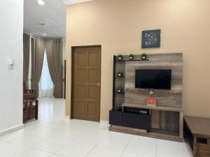 a living room with a flat screen tv on a wall at Zuriana Ashraf Homestay Kota Bharu in Kota Bharu