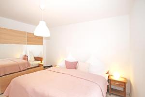 a bedroom with two beds and a pink blanket at Apartmenthaus Strandstraße 34 in Kühlungsborn