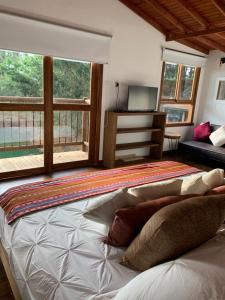 a bedroom with a bed and a large window at Serendipity Hospedaje Boutique in Guatapé