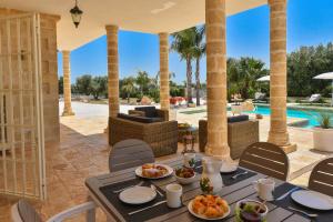 a patio with a table and chairs and a pool at Villa Merlata in Ostuni