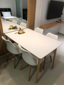 a white table and chairs in a room at Just Chillin Pool & Seaview Suites in Kota Kinabalu