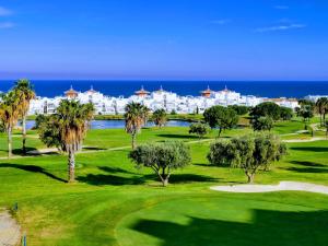 a view of a golf course with a resort in the background at La Paratá Suites Mojácar in Mojácar
