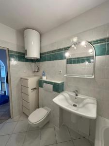 a white bathroom with a toilet and a sink at Luna Apartments in Krakow