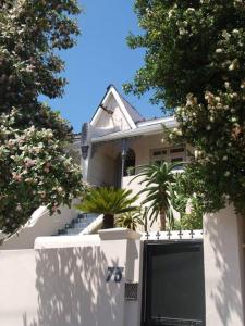 una casa blanca con una puerta y árboles en On Salisbury, en Ciudad del Cabo