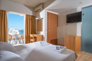 a hotel room with a bed and a balcony at Kitro Beach Hotel - Adults Only in Agios Nikolaos