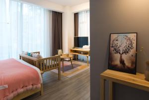 a bedroom with a crib and a bedroom with a room with at Zhangjiajie Twelve Warm Inn-Tianmen Mountain Ropeway Station in Zhangjiajie