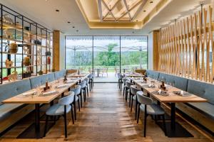 uma fila de mesas num restaurante com janelas grandes em Falkensteiner Family Hotel Montafon - The Leading Hotels of the World em Schruns